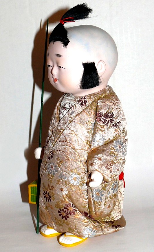 japanese kimekomi doll of a boy with twig